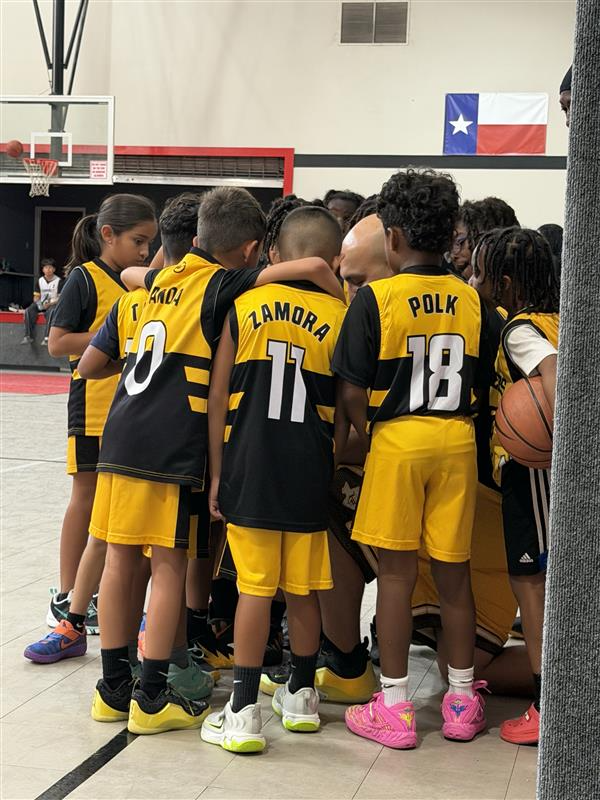 Stingers Basketball youth team huddled up in black and gold uniforms